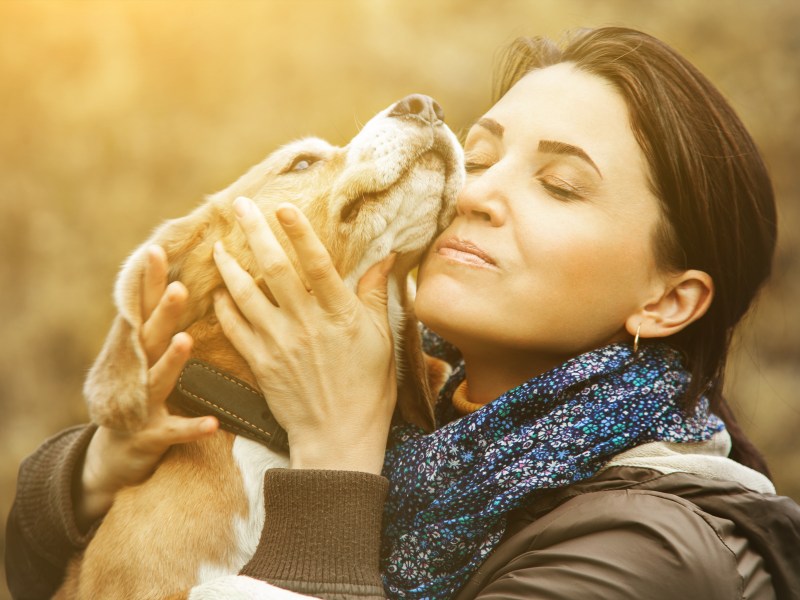 Frau kuschelt mit Hund