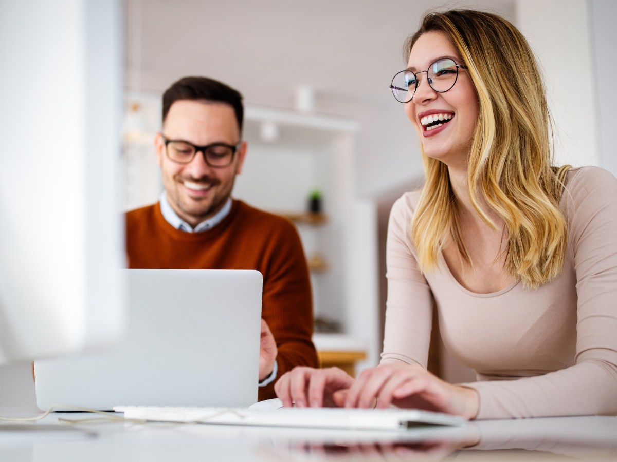 Ein Mann und eine Frau sitzen im BÃ¼ro am Laptop.