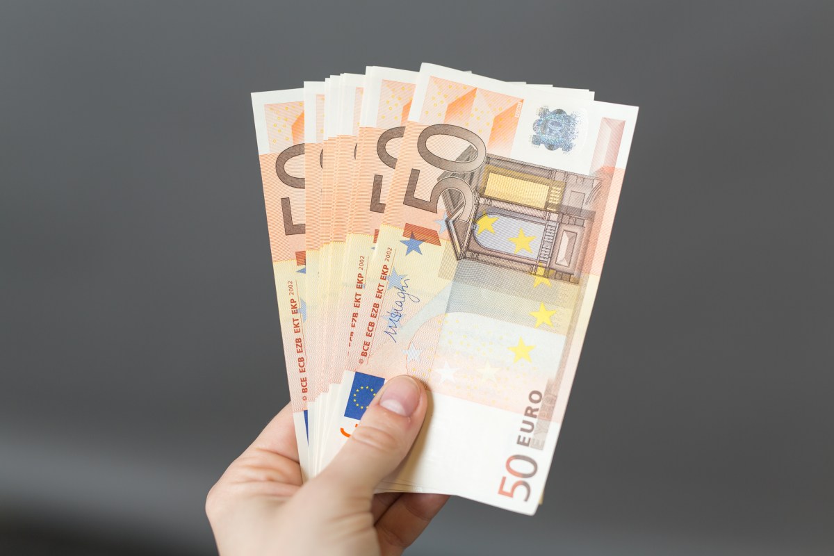 Eine Person hÃ¤lt mehrere 50-Euro-Scheine in der Hand.