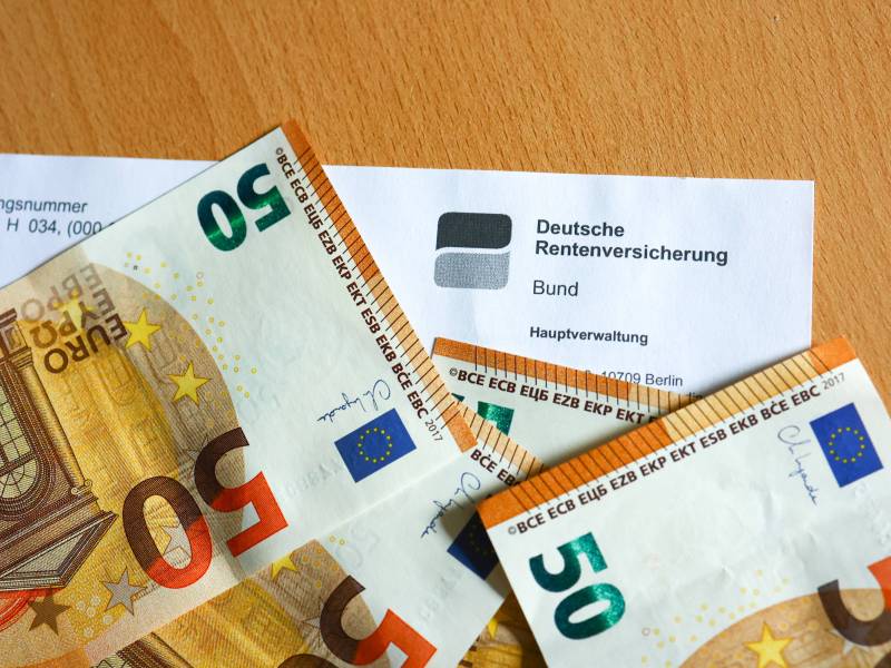 Neben einem Bescheid der Deutschen Rentenversicherung liegen drei 50-Euro-Scheine.