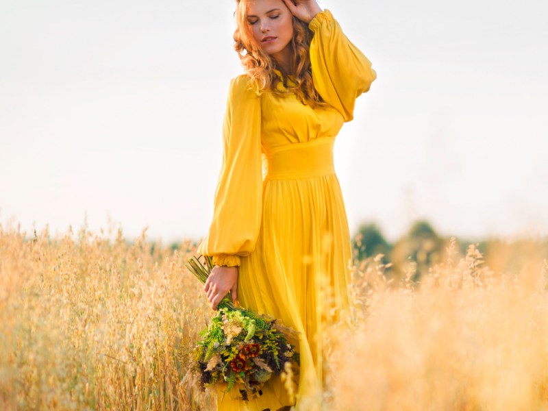 Frau mit Blumenkranz in Feld