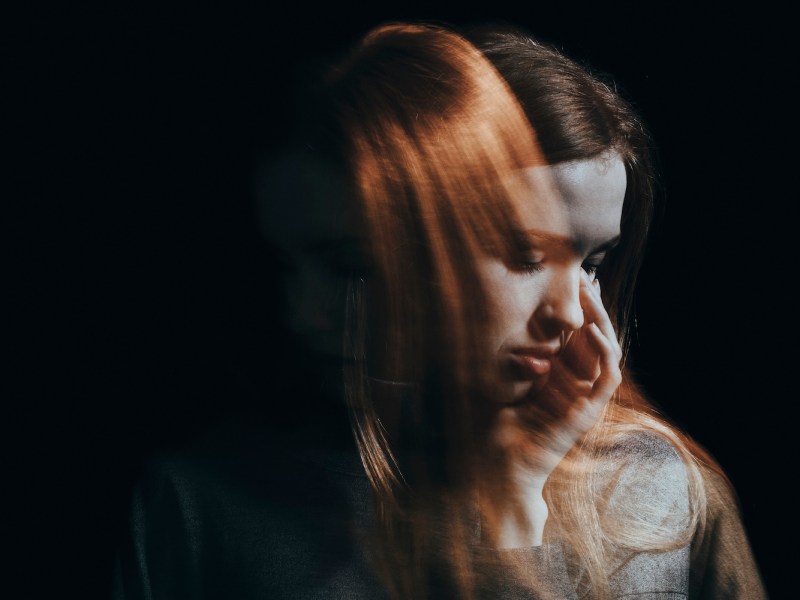 Eine Frau mit roten Haaren sieht erschöpft aus.