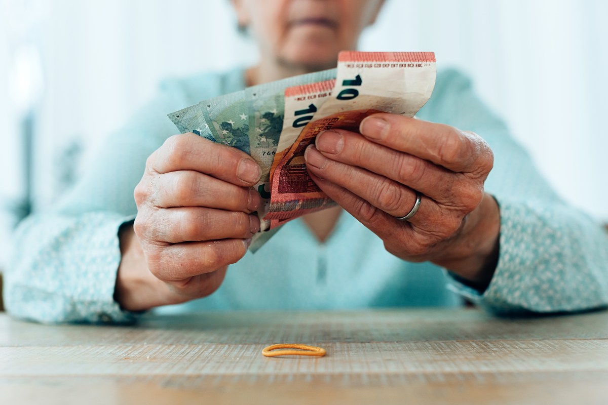 Eine Seniorin hÃ¤lt Geldscheine in der Hand.