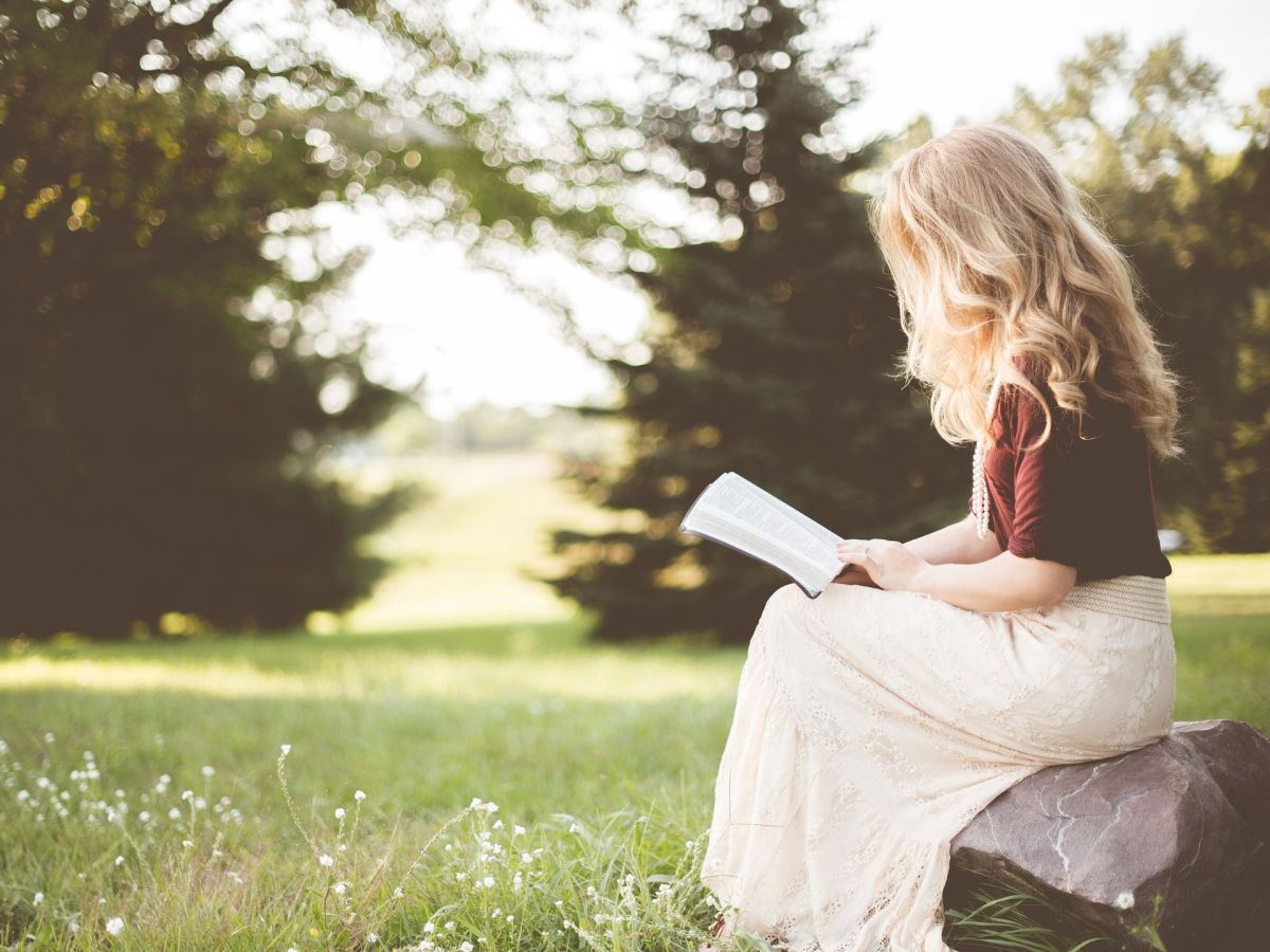 PersÃ¶nlichkeitstest: Frau liest Buch in der Natur (Symbolbild)