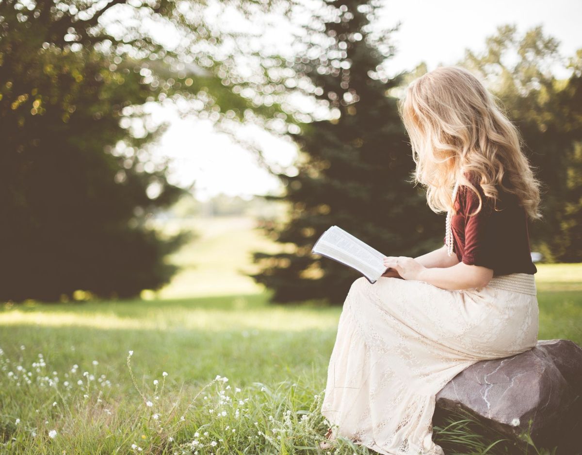 PersÃ¶nlichkeitstest: Frau liest Buch in der Natur (Symbolbild)