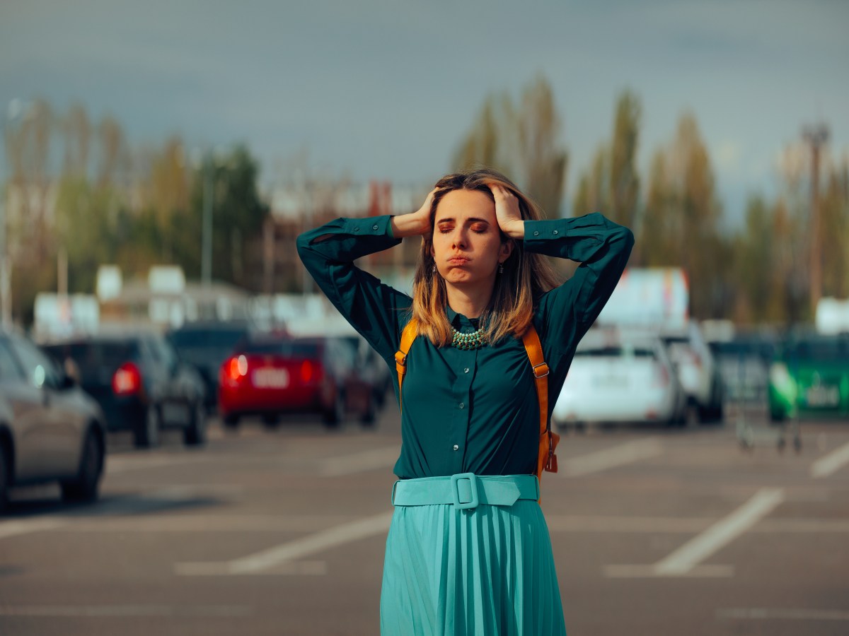 Frau steht auf Parkplatz und sucht Auto