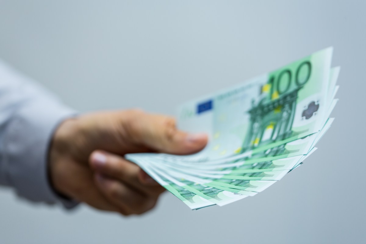 Ein Mann hält mehrere 100-Euro-Scheine in der Hand.