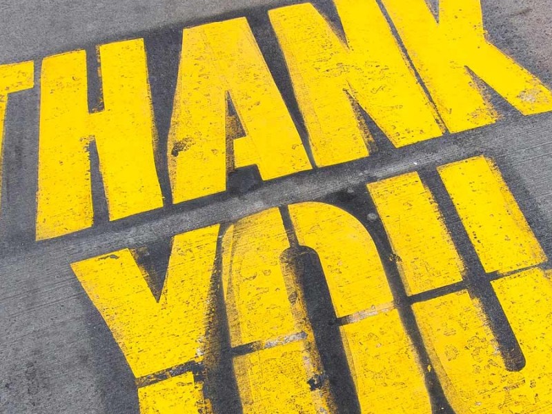 Dankbarkeit: Die Worte "Thank you" auf Asphalt gesprayed.