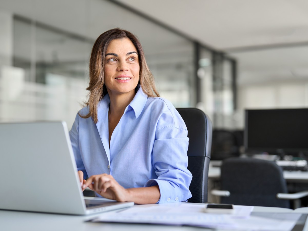 Eine Frau sitzt im Büro an ihrem Laptop.