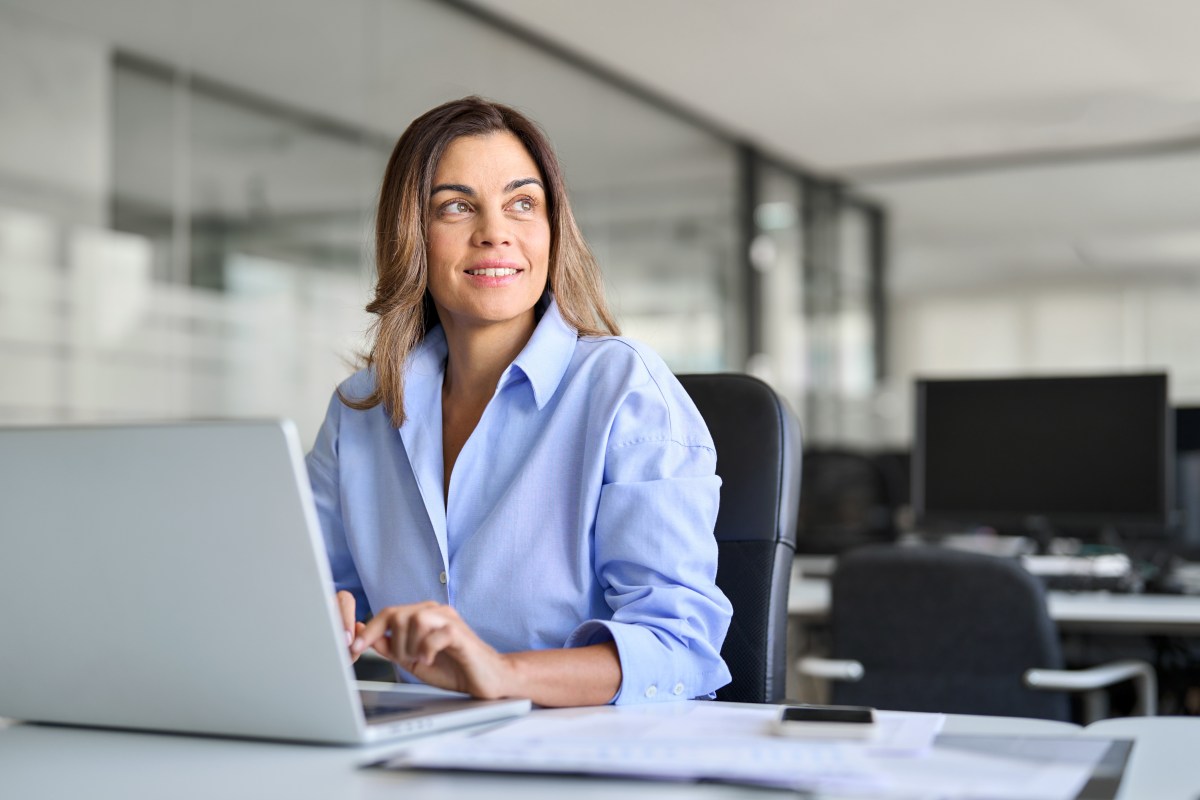 Eine Frau sitzt im BÃ¼ro an ihrem Laptop.