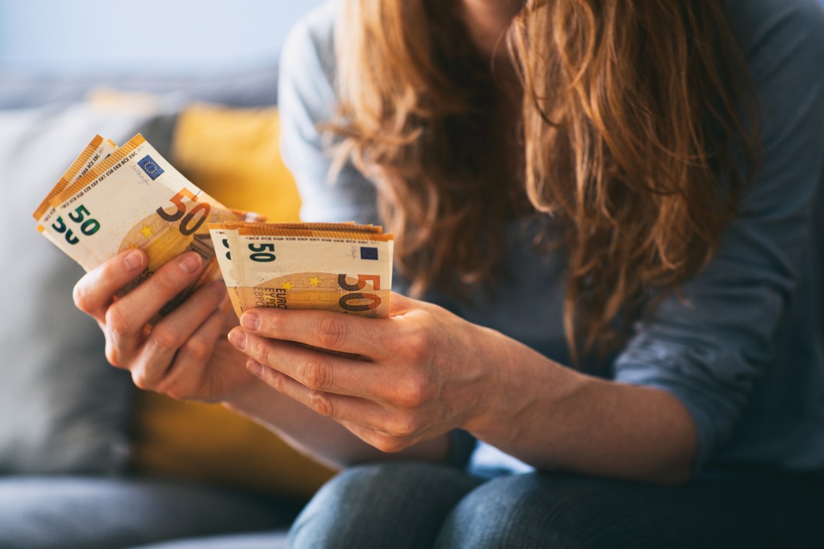 Eine Frau hält mehrere 50-Euro-Scheine in der Hand.