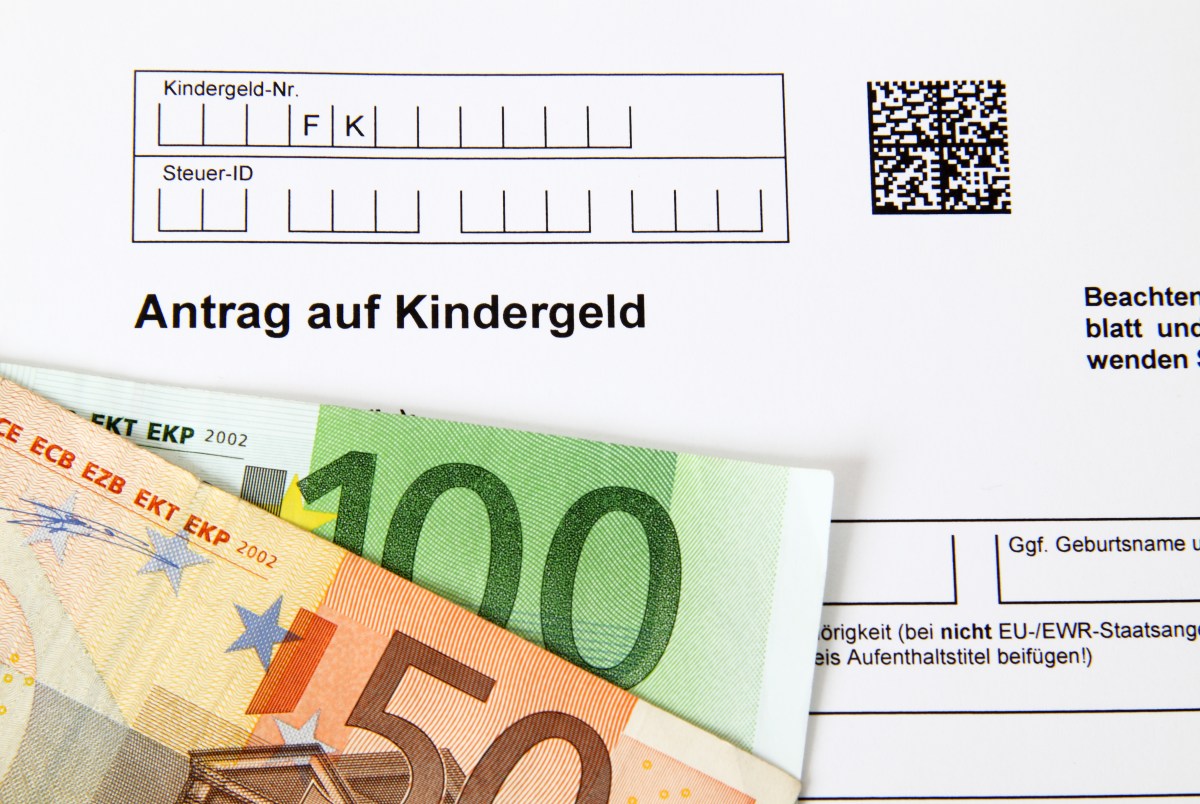 Auf einem Kindergeld-Antrag liegen zwei Geldscheine.