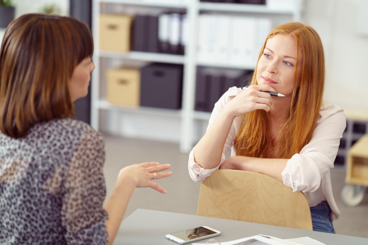 Zwei Frauen fÃ¼hren im BÃ¼ro ein MitarbeitergesprÃ¤ch.