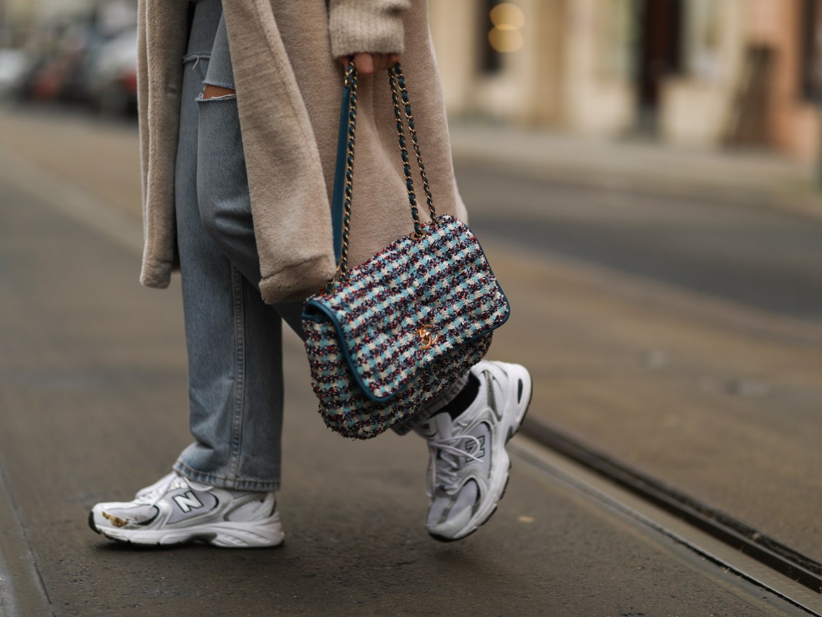 Frau geht in New Balance Sneakern Ã¼ber StraÃŸe.