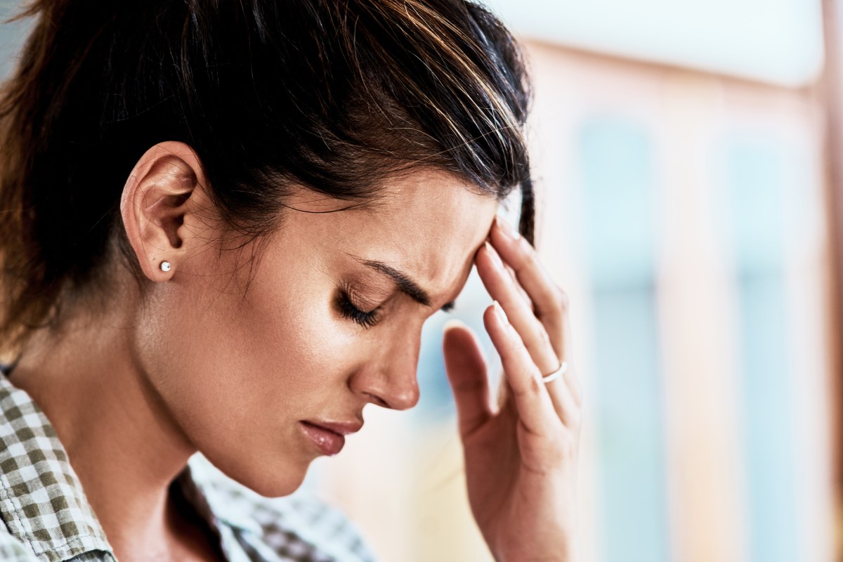 Frau mit Burnout fasst sich an die Stirn