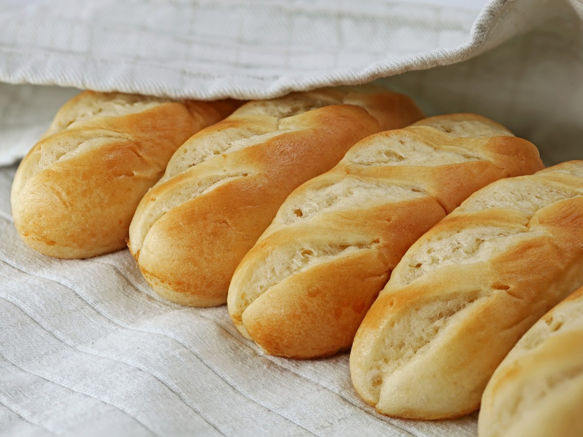 MilchbrÃ¶tchen selber machen: MilchbrÃ¶tchen auf einer weiÃŸen Unterlage bedeckt von einem weiÃŸen Tuch.