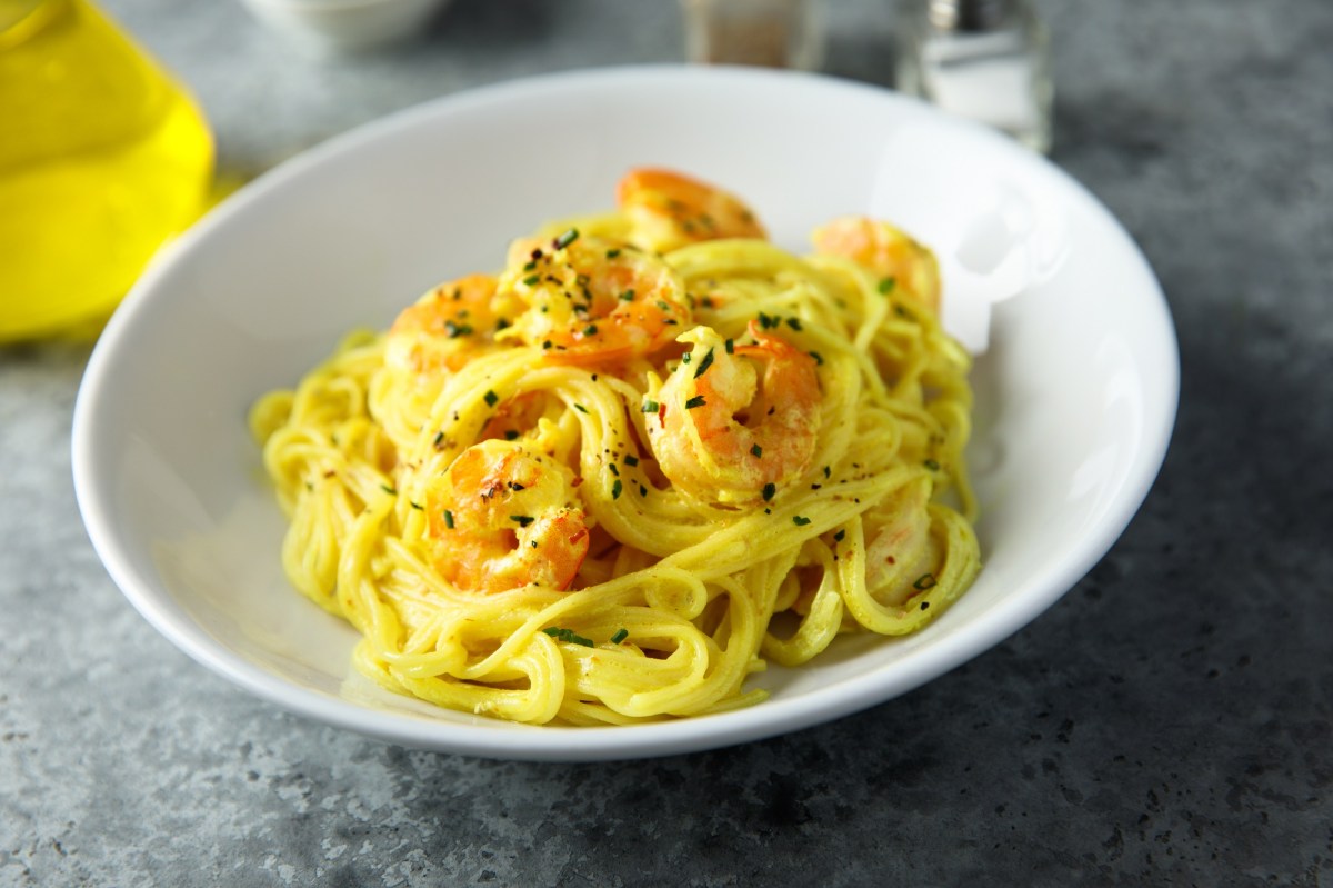 Ein weiÃŸer Teller mit Safran-Pasta mit Garnelen