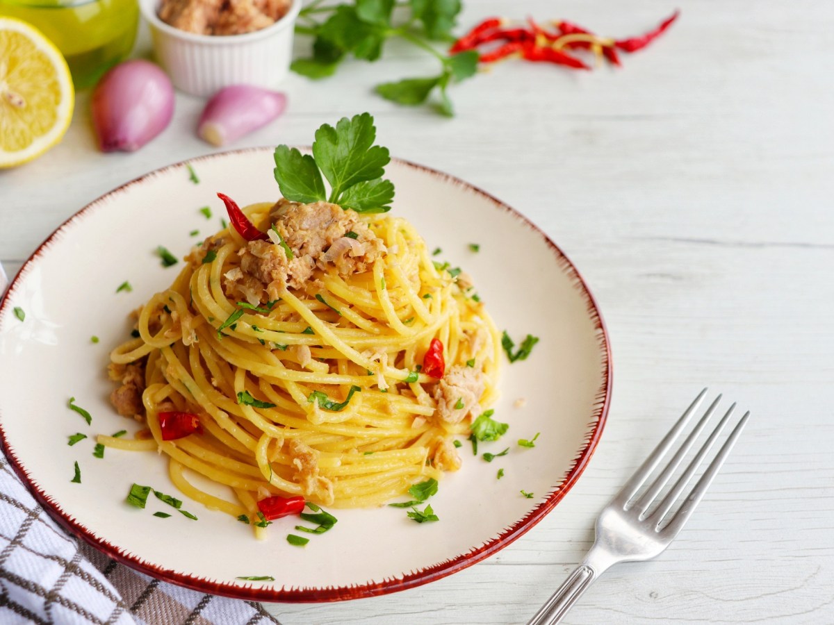 Teller mit Spaghetti mit Thunfisch und Gabel daneben