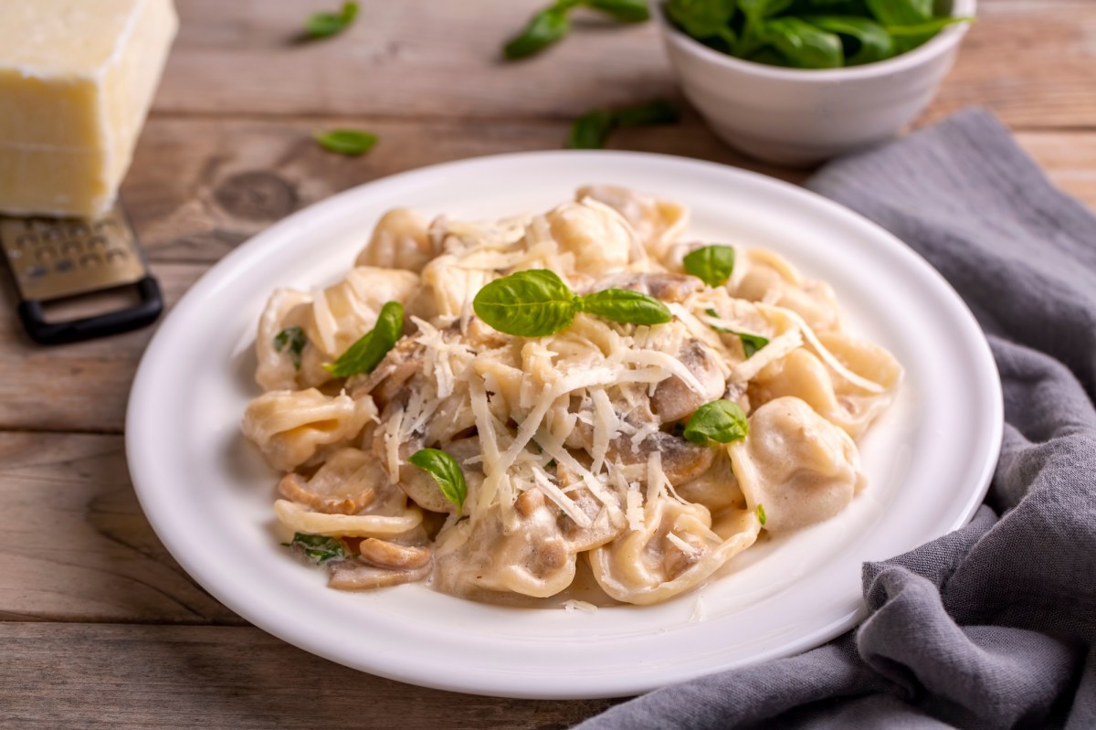 Tortellini in Pilzsoße auf einem Teller.