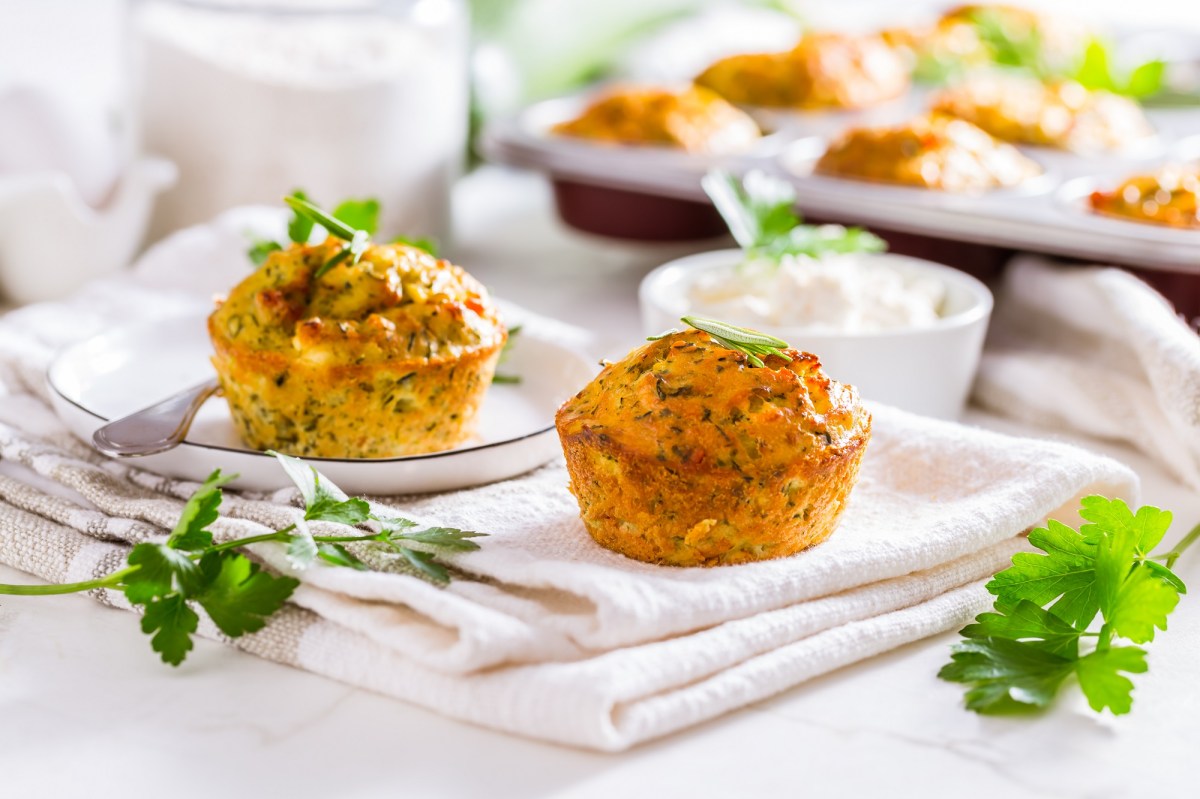 Zwei Zucchini-Feta-Muffins auf einem Tuch.