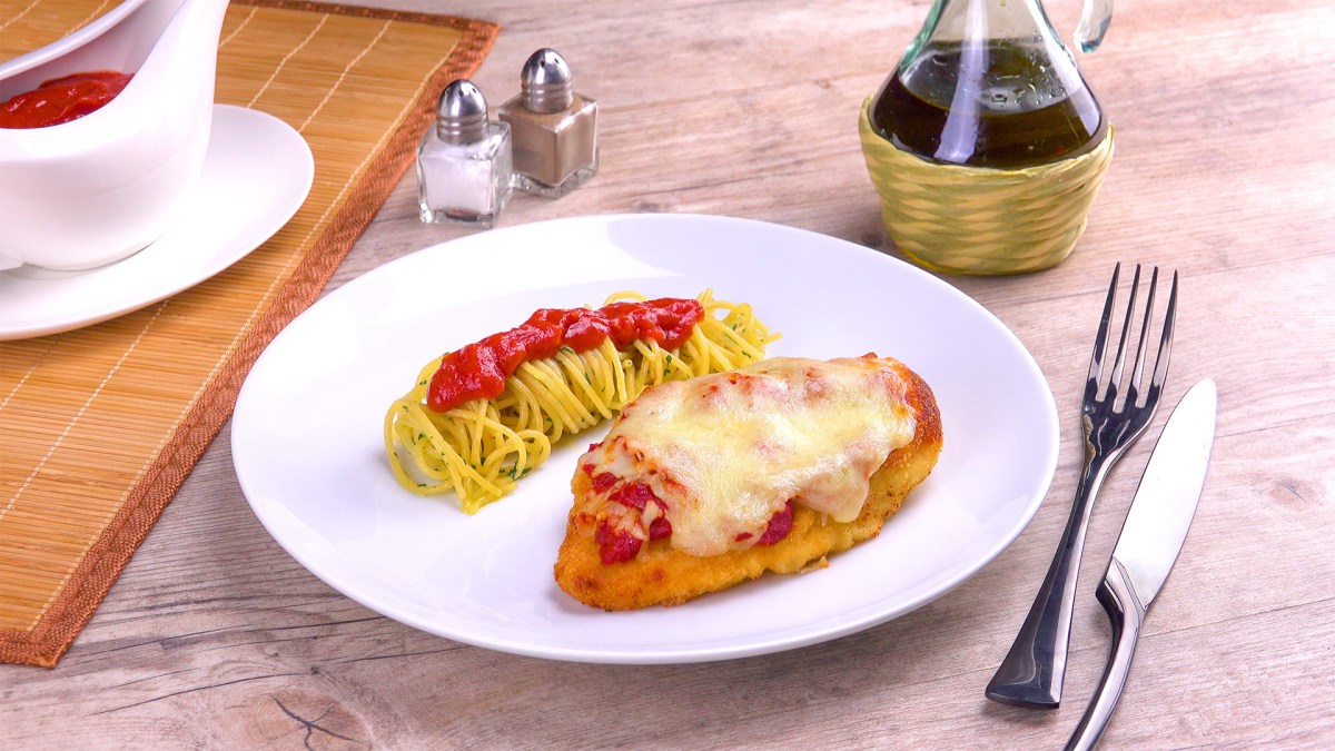 Parmesan-HÃ¤hnchen mit Nudeln und TomatensoÃŸe auf einem Teller.