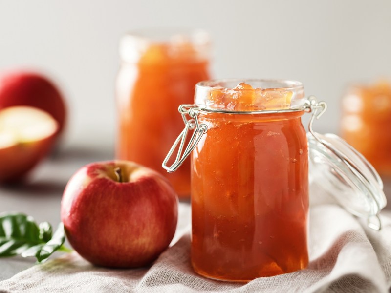 Drei GlÃ¤ser Apfelgelee und frische Ã„pfel