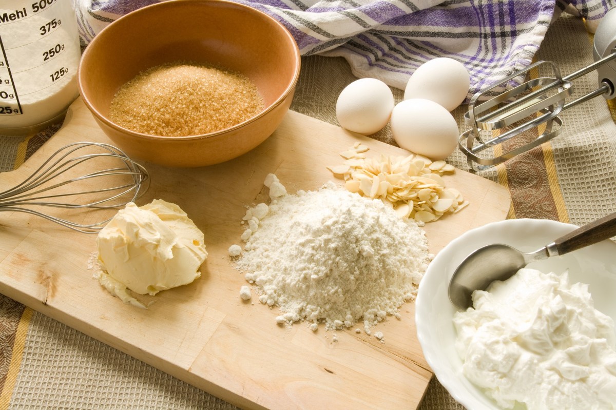 Backmischung aufpeppen: Backutensilien wie Mehl, Butter, Zucker und Eier sowie RÃ¼hrstÃ¤be eines Handmixers. Nahaufnahme.