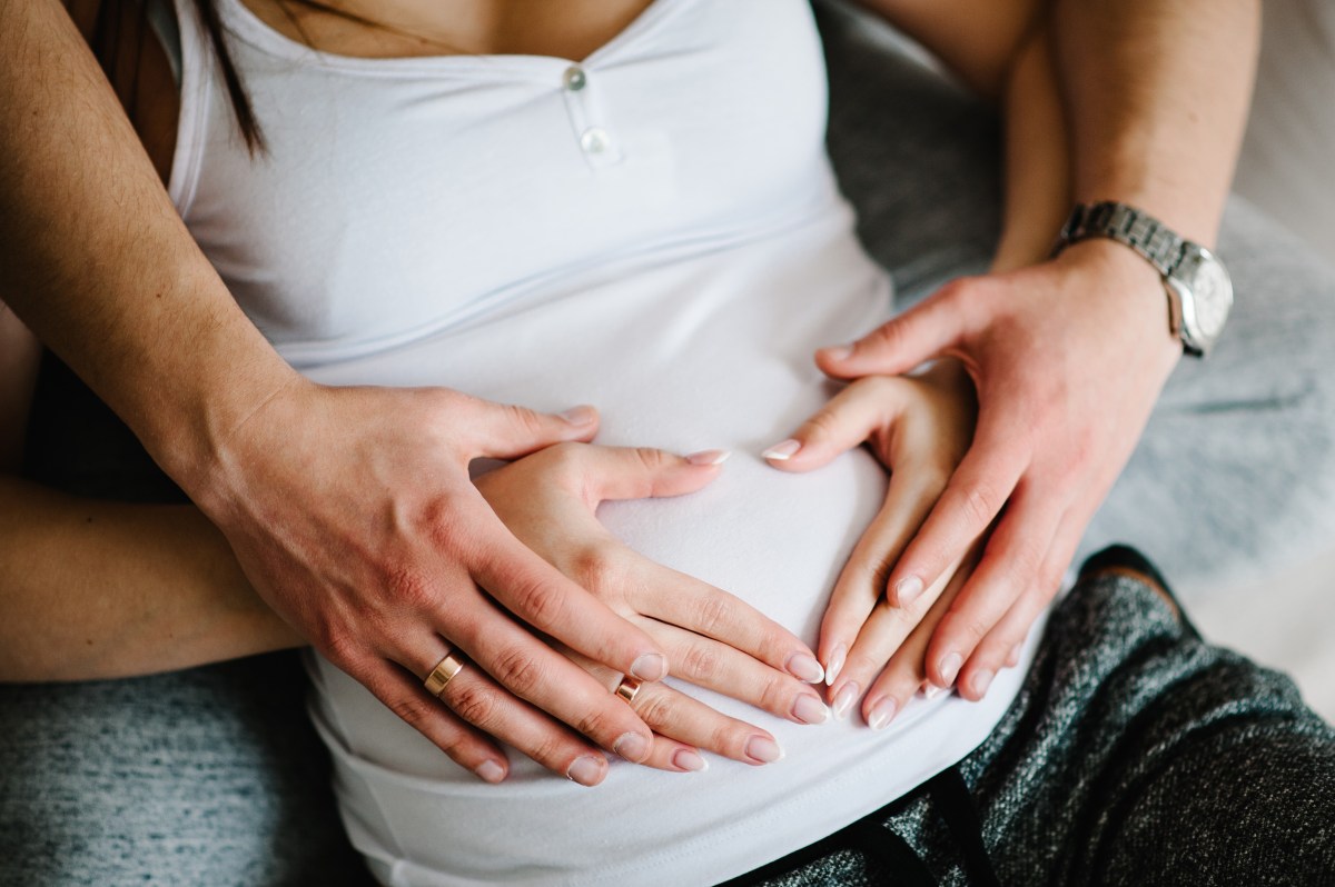 Ausgeschnittenes Bild eines Mannes, der den Bauch seiner schwangeren Frau hÃ¤lt.