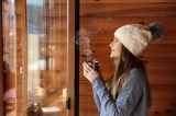 Eine Frau mit Mütze trinkt einen Glühwein.