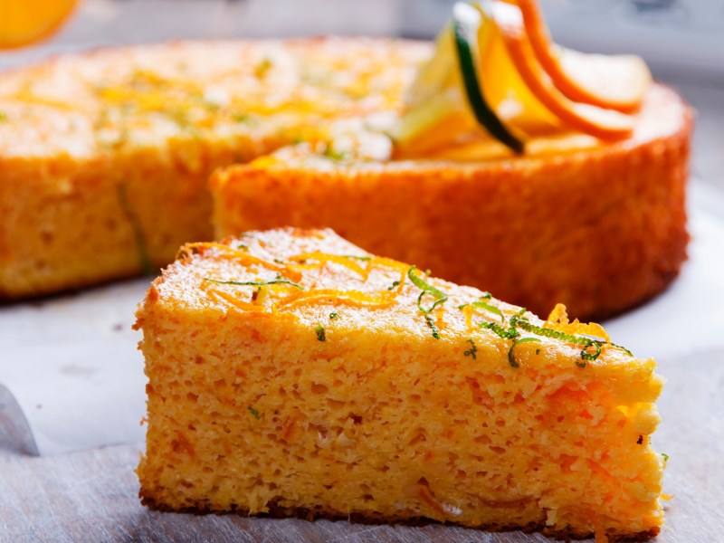 Ein StÃ¼ck saftiger Orangen-Mandel-Kuchen mit Zeste bestreut.