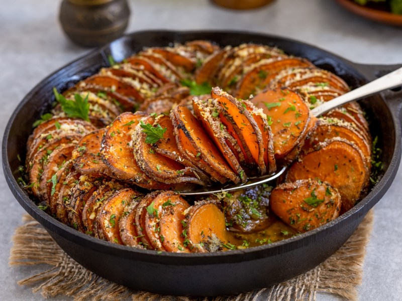 Eine gusseiserne Pfanne mit SÃ¼ÃŸkartoffelgratin.