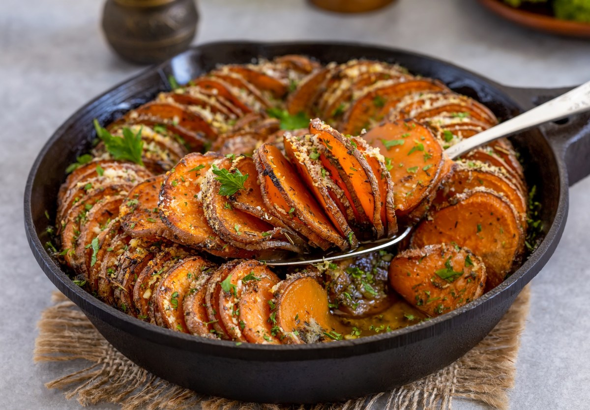 Eine gusseiserne Pfanne mit SÃ¼ÃŸkartoffelgratin.