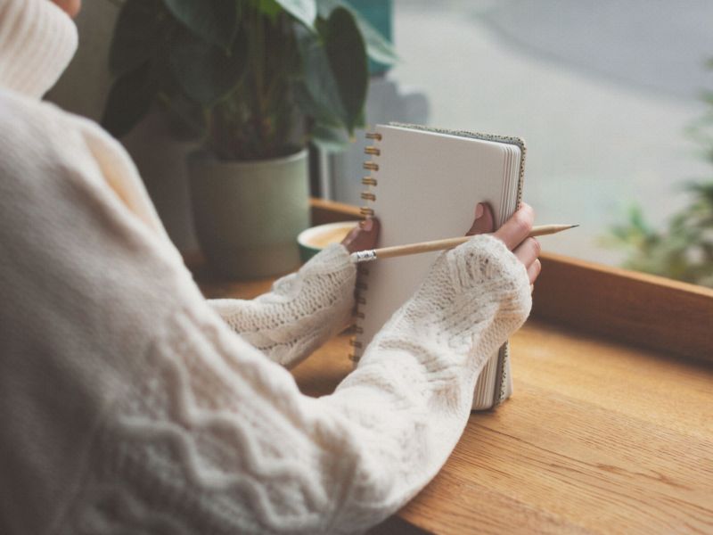 Frau hält Ta-Da-Liste Notizblock in der Hand