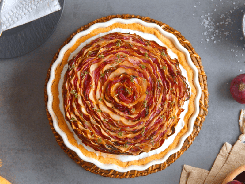 Zwiebelkuchen mit MÃ¼rbeteig, serviert in einer Tarteform.