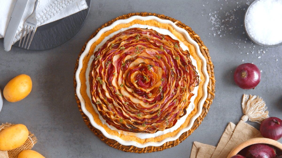 Zwiebelkuchen mit MÃ¼rbeteig, serviert in einer Tarteform.