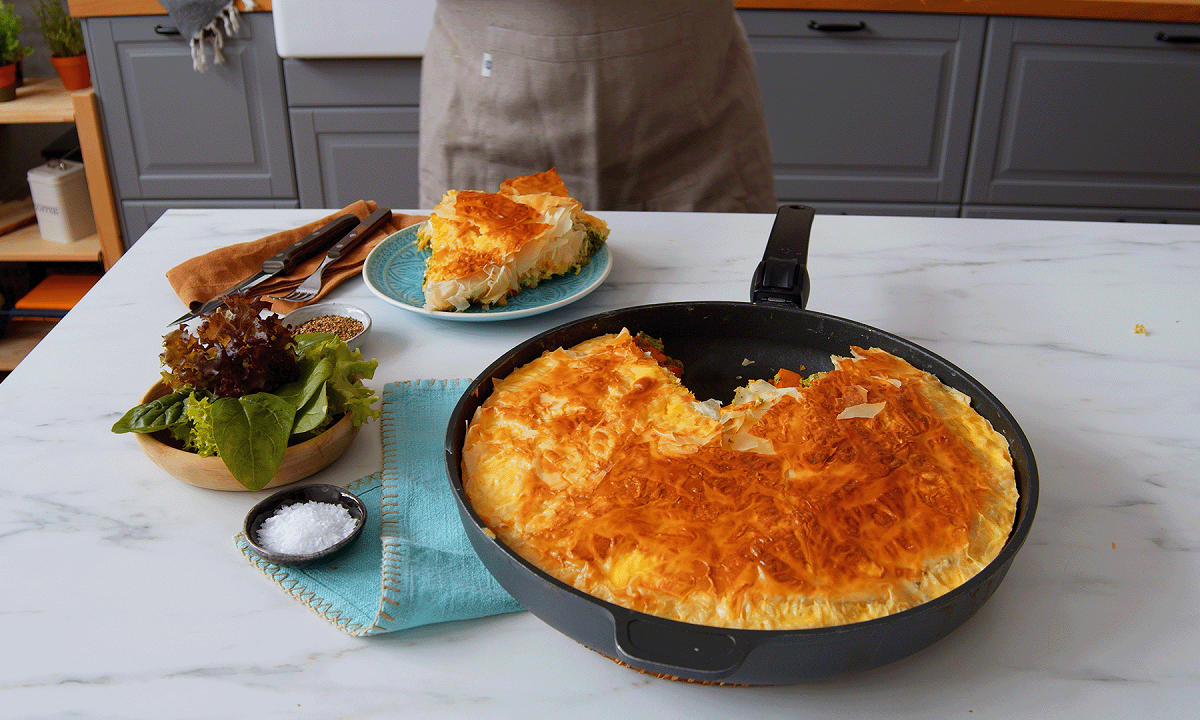 Eine herbstliche BÃ¶rek-Pfanne mit KÃ¼rbis und Yufka-Teig auf einer KÃ¼chentheke, daneben eine Schale Salz und ein Teller mit einem StÃ¼ck des Auflaufes.