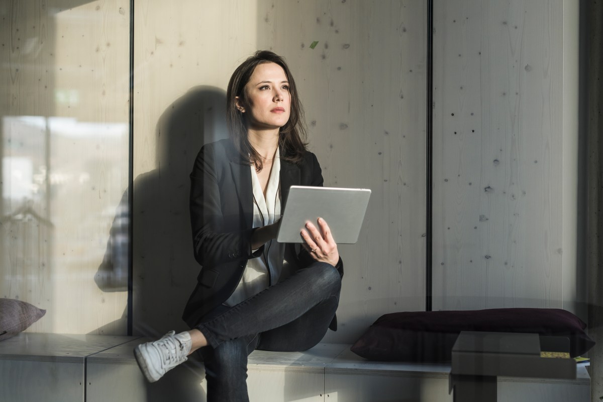 GeschÃ¤ftsfrau mit Tablet sitzt im Loungebereich im BÃ¼ro.