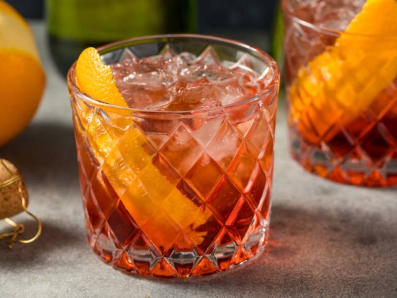 Zwei GlÃ¤ser Negroni Sbagliato mit einer Orangenspalte.