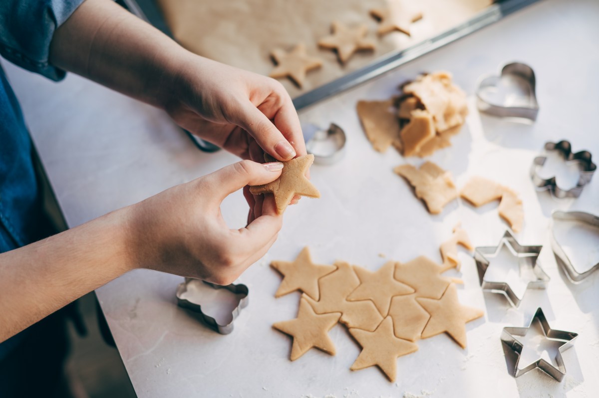 Junge Frau bereitet WeihnachtsplÃ¤tzchen auf dem Tisch zu.