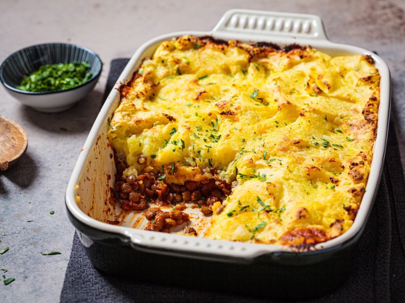 Shepherd's Pie mit Hack und Kartoffelbrei in einer Auflaufform mit Petersilie bestreut, ein StÃ¼ck ist schon weg