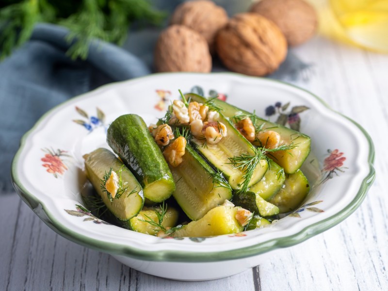 Zucchinisalat mit Walnuss und Dill in einer gemusterten Schale