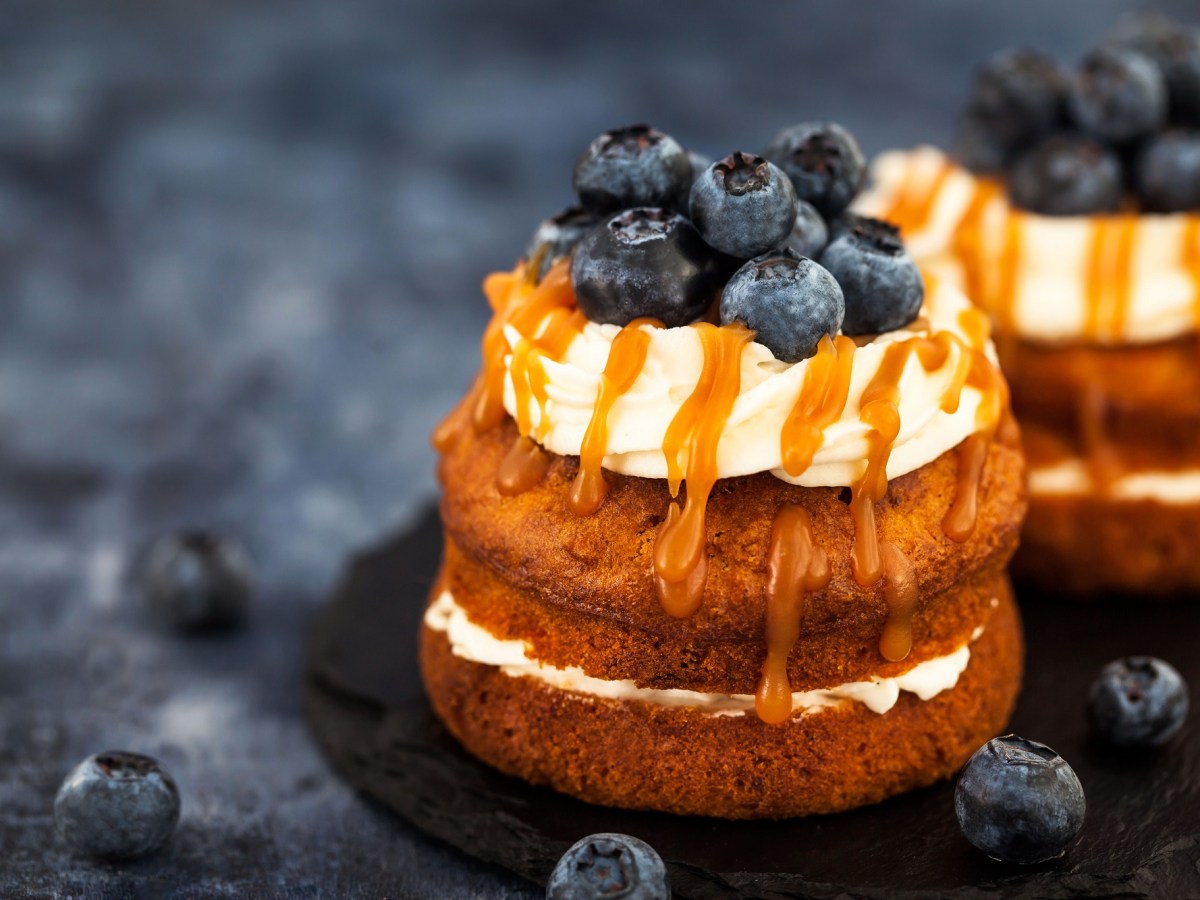 2 Cupcake-Sandwiches mit Heidelbeeren und KaramellsoÃŸe verziert.