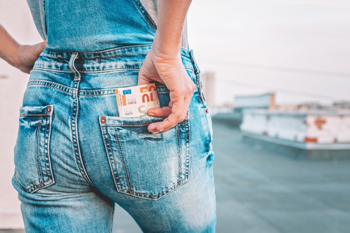 Die Hand einer Frau holt Euro-Scheine aus der GesÃ¤ÃŸtasche ihrer Jeans.