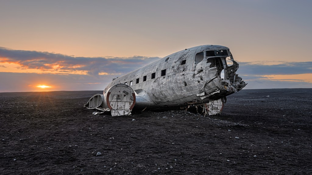 Bei Sonnenuntergang aufgenommen: Das Wrack eines Absturzes von 1973, eine DC-3, die in Sólheimasandur, Island, abstürzte, nachdem ihr der Treibstoff ausgegangen war.