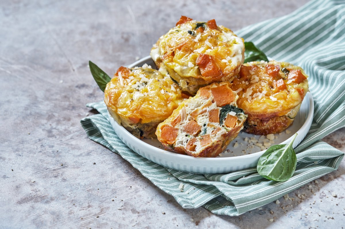 4 Kroketten-Muffins mit GemÃ¼se und Schmand auf einem Teller, der auf einem gestreiften Geschirrtuch steht.