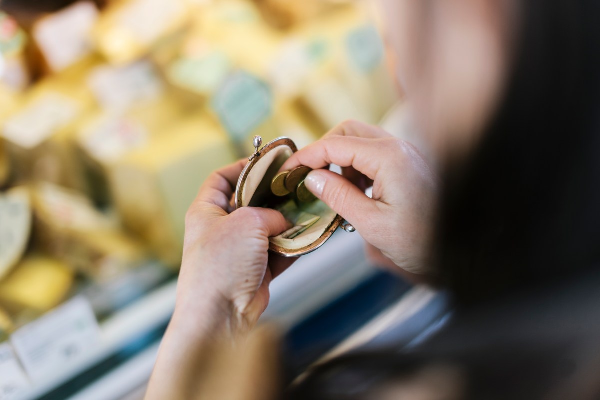 Nahaufnahme einer Frau, die am Marktstand bezahlt. Sie hÃ¤lt eine GeldbÃ¶rse in der Hand.