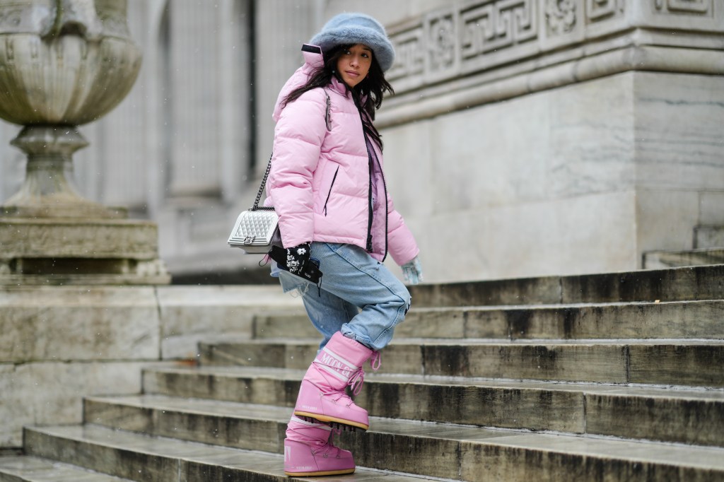 Frau mit Daunenjacke und Schneestiefel.