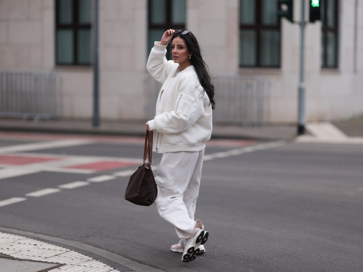 Frau im weiÃŸen Outfit mit Sneakern