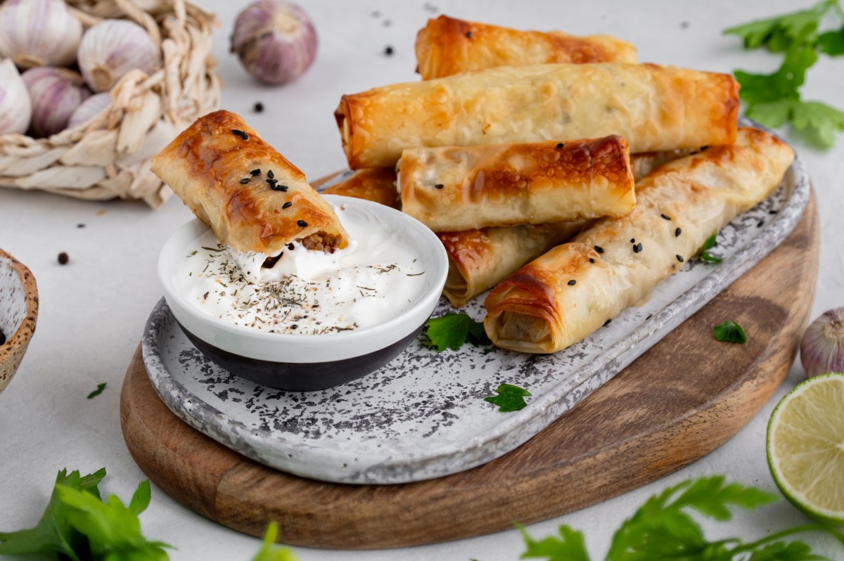 Feta-RÃ¶llchen auf einem Tablett mit Dip.