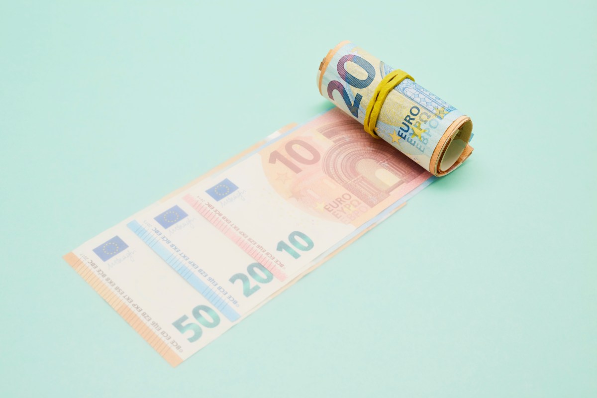 Rolle Euro-Banknoten auf türkisfarbenem Hintergrund